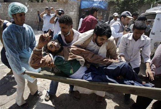 Yemeni anti-government protestors carry an injured protestor from the site of clashes with security forces, in Sanaa, Yemen, on Tuesday, Sept. 20, 2011. Rapidly escalating street battles between opponents of Yemen's regime and forces loyal to its embattled president spread to the home districts of senior government figures and other highly sensitive areas of the capital on Tuesday. 